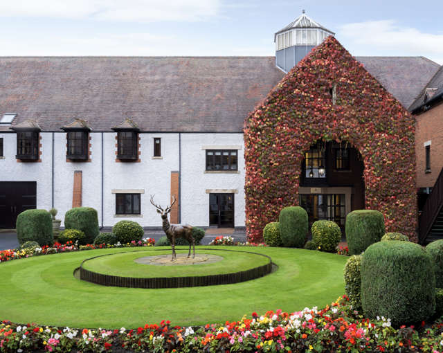 Forest of Arden near Birmingham entrance with ivy-clad archway, deer statue, manicured lawns and flower beds